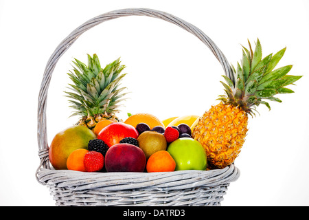 Composizione con frutti assortiti in cesto in vimini isolato su bianco Foto Stock