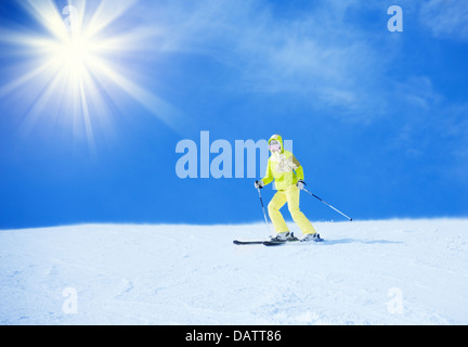 Felice donna giovane sciatore in sgargianti abiti in discesa con sfondo pulito Foto Stock