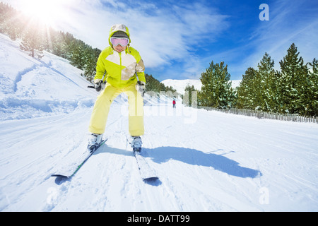 Felice donna giovane sciatore in sgargianti abiti in discesa Foto Stock