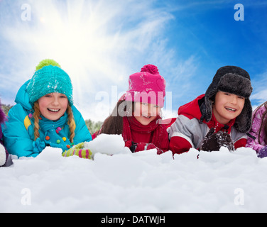 Gruppo di tre bambini 5-10 anni bambini e bambine sulla neve in un giorno di fila in montagna Foto Stock