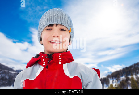 Volto ritratto di felice dieci anni ragazzo sulla giornata invernale, indossando vestiti di rosso Foto Stock