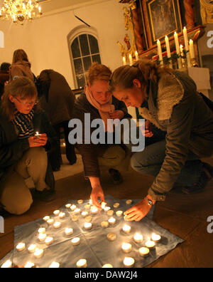 Residenti accendono le candele a un memoriale di servizio in San Dionigi la Chiesa per le vittime degli assassinii perpetrati in Sittensen, Germania, Mercoledì, 07 febbraio 2007. Sette persone sono state uccise in un ristorante Cinese di Sittensen Lunedì, 05 febbraio 2007. Foto: Carmen Jaspersen Foto Stock