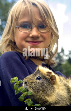 Una ragazza detiene una cavia nelle sue braccia in Germania, Giugno 2006. Foto: Jens Schierenbeck Foto Stock