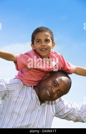 Felice padre nero e il sole la riproduzione e portante little boy Foto Stock