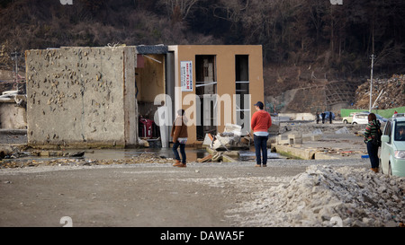 Una casa rovesciato al gravemente danneggiato e livellata Onagawa 1 anno dopo il 2011 Tohoku Terremoto e Tsunami Foto Stock