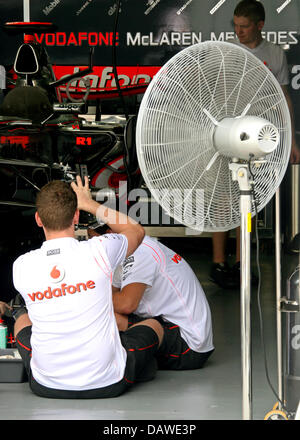 I meccanici della McLaren Mercedes lavorare su Lewis Hamilton della vettura da corsa con una ventola di raffreddamento motivo del calore sul circuito di Sepang vicino a Kuala Lumpur, Malesia, giovedì 05 aprile 2007. 2007 la Formula 1 Gran Premio di Malesia si svolgerà sul circuito di Sepang vicino a Kuala Lumpur, domenica 08 aprile. Foto: GERO BRELOER Foto Stock