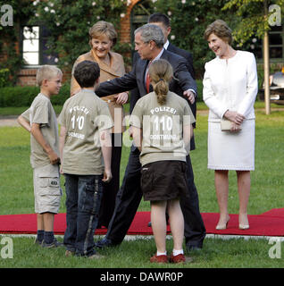 Il Presidente degli Stati Uniti George W. Bush (2-R) chat con i bambini quando lui e la sua moglie Laura (R) sono accolti dal Cancelliere tedesco Angela Merkel (L) e il marito Joahcim Sauer (nascosta) per una cena informale a Hohen Luckow, Germania, 06 giugno 2007. Foto: Bernd Settnik Foto Stock