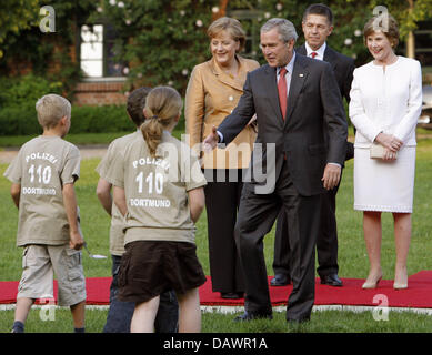 Il Presidente degli Stati Uniti George W. Bush (2-R) chat con i bambini quando lui e la sua moglie Laura (R) sono accolti dal Cancelliere tedesco Angela Merkel (L) e il marito Joahcim Sauer (nascosta) per una cena informale a Hohen Luckow, Germania, 06 giugno 2007. Foto: Bernd Settnik Foto Stock