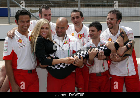 US-modello americano Bridget Lee pone con meccanici Ferrari in pista a Indianapolis, Stati Uniti d'America, 14 giugno 2007. Il Gran Premio degli Stati Uniti si svolgerà a Indianapolis domenica 17 giugno. Foto: GERO BRELOER Foto Stock