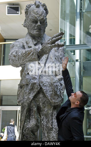 Il cantante della Irish rock band U2, Bono cerca di toccare la statua di Willy Brandt a Berlino, Germania, 14 maggio 2007. Bono si è incontrato con il presidente SPD Kurt Beck per colloqui 3 settimane prima del vertice G8 di Heiligendamm. Bono sostiene l'iniziativa "eine Stimme gegen Armut" ("La vostra voce contro la povertà"), ha chiesto ulteriori aiuti allo sviluppo e il rispetto degli impegni. Foto: Johannes Eisel Foto Stock