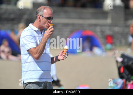 BARRY island, Regno Unito. Il 19 luglio 2013. Il British ondata di caldo continua e persone affollano le spiagge in Galles del Sud. Un uomo utilizza il tempo come una scusa per avere due coni gelato. Foto di Credito Credito: Polly Thomas / Alamy Live News Foto Stock