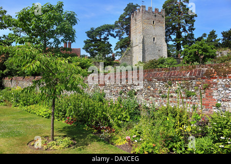 Un inglese un giardino murato con chiesa in background Foto Stock