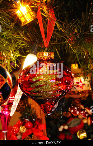 Rosso e oro di Natale di vetro globe appeso a un albero di Natale. Foto Stock