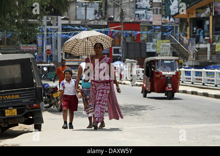 Donna con ombrello & BAMBINO PERADENIYA SRI LANKA 12 Marzo 2013 Foto Stock