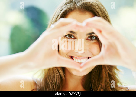 Ragazza messa a forma di cuore con le mani Foto Stock