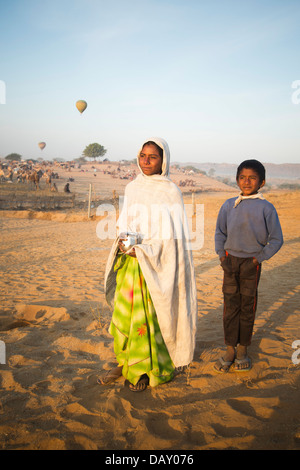 Donna con suo figlio e tenendo un lota (recipiente dell'acqua) nel deserto, Pushkar, Ajmer, Rajasthan, India Foto Stock