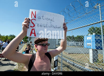 Berlino, Germania. Il 20 luglio, 2013. A poche centinaia di persone prendono parte a una protesta al di fuori di un US National Security Agency (NSA) stazione di ascolto in Griesheim vicino a Darmstadt, Germania, 20 luglio 2013. Come parte del "Picknick' azione, participents assemblato al di fuori dell'strettamente limitata US Army 'Dagger complessa" bloccando temporaneamente la strada. Foto: BORIS ROESSLER/dpa/Alamy Live News Credito: dpa picture alliance/Alamy Live News Foto Stock