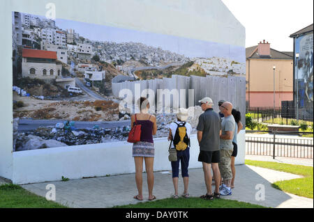 Derry/Londonderry, NI, UK. Il 20 luglio 2013. L'iconico Free Derry Wall, nel Bogside, è stato trasformato in questo fine settimana come immagini dal premiato fotografo Kai Wiedenhofer vai sul display simultaneamente in Derry e il muro di Berlino in questo mese. Per gli ultimi sette anni, il premiato Wiedenhofer ha documentato pareti di pace in tutto il mondo ed è diventato qualcosa di una figura iconica in Germania per la sua vista panoramica visualizza montato sul muro di Berlino. L'immagine visualizzata sulla libera Derry muro è stato preso nel Medio Oriente. Photo credit: George Sweeney / Alamy Live News. Foto Stock