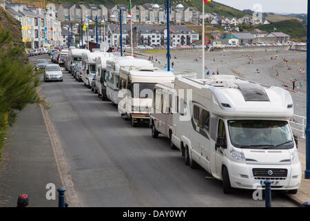 Aberystwyth, Wales, Regno Unito, 20 luglio 2013, camper van proprietari che park lungo Aberystwyth promenade rendono la maggior parte dell'ondata di caldo e la mancanza di restrizioni di parcheggio. Sabato, 23 i camper sono state contate parcheggiate lungo la promenade. Alcuni residenti locali hanno denunciato che avendo furgoni parcheggiati costantemente giorno e notte sul primo lungomare, con "residenti" che si estende e la fuoriuscita delle loro aree salotto sul marciapiede, è dannoso per la città. Credito: atgof.co/Alamy Live News Foto Stock