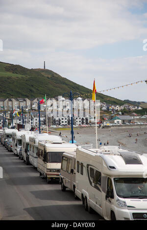 Aberystwyth, Wales, Regno Unito, 20 luglio 2013, camper van proprietari che park lungo Aberystwyth promenade rendono la maggior parte dell'ondata di caldo e la mancanza di restrizioni di parcheggio. Sabato, 23 i camper sono state contate parcheggiate lungo la promenade. Alcuni residenti locali hanno denunciato che avendo furgoni parcheggiati costantemente giorno e notte sul primo lungomare, con "residenti" che si estende e la fuoriuscita delle loro aree salotto sul marciapiede, è dannoso per la città. Credito: atgof.co/Alamy Live News Foto Stock