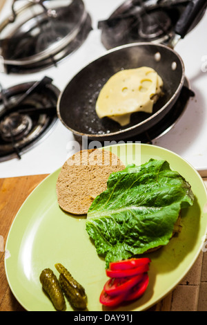 Una lauta turchia hamburger con basso contenuto di grassi di formaggio svizzero e il pane sottile round con sottaceti grigliate di cipolla pomodoro e lattuga romana Foto Stock