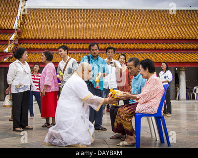 Bangkok, Tailandia. 21 Luglio, 2013. Un giovane uomo di entrare nel monastero per Vassa rende un offrendo ai suoi genitori al Wat Benchamabophit sul primo giorno del Vassa, i tre mesi di ritiro annuale osservata dai monaci Theravada e monache. Gli uomini spesso immettere il monastero e diventare monaci buddisti per Vassa. Il primo giorno di Vassa (o la Quaresima buddista) molti buddisti visita i loro templi a ''make merito.'' durante Vassa, monaci e monache rimangono all' interno dei monasteri e tempio motivi, dedicando il proprio tempo a intensivo di meditazione e di studio. I laici supportano il sangha monastico da portare cibo, candele e Foto Stock