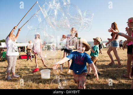 Oakhampton, UK. Il 20 luglio, 2013. Bambini chase bolle a Chagstock, un piccolo festival di musica vicino a Okehampton, Devon. Il tutto esaurito caso visto i frequentatori del festival godendo il caldo clima soleggiato che ha basked regno unito di recente. Il Met Office ha retrocesso l'ondata di caldo livello di avvertimento ma le temperature dovrebbero salire nuovamente durante la prossima settimana. 20 luglio 2013 Credit: Adam Gasson/Alamy Live News Foto Stock