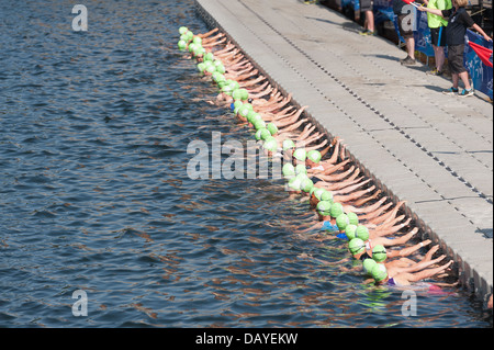 Uomini Elite Sprint Triathlon atleti supremo super montare e fodera veloce fino sotto gli ordini di antipasti sul pontone acqua profonda Foto Stock