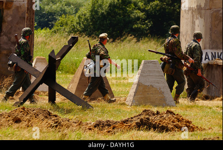 Re-enactors vestiti come i soldati tedeschi durante la simulazione di una battaglia in un militare di mostrare, REGNO UNITO Foto Stock