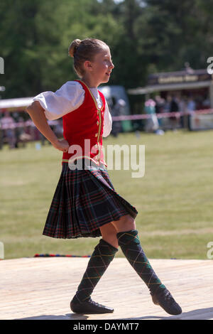 Tomintoul, Regno Unito. 20 luglio 2013. Ballerini tradizionali delle Highland reel durante i giochi e gli incontri annuali di Tomintoul Scottish che si tengono il 3° sabato di luglio presso lo showground del villaggio. Questo villaggio delle Highland ospita un evento sportivo, storico e tradizionale nel mese di luglio, nel Cairngorms National Park, uno dei migliori e più famosi Giochi delle Highland in Scozia. Gli incontri delle Highlands hanno una lunga tradizione e storia quando concorrenti, musicisti e ballerini dei Clans rivali, che erano importanti per il prestigio del capo clan, si contenderebbero gli uni contro gli altri in eventi sportivi. Foto Stock