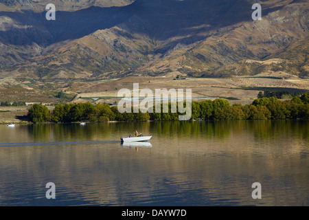 Il lago di Dunstan, Pisa di gamma e di persone in barca da pesca di Central Otago, Isola del Sud, Nuova Zelanda Foto Stock
