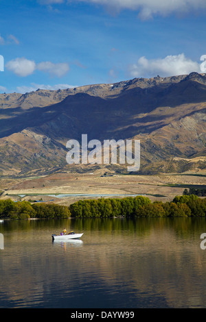 Il lago di Dunstan, Pisa di gamma e di persone in barca da pesca di Central Otago, Isola del Sud, Nuova Zelanda Foto Stock