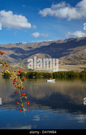 Il lago di Dunstan, Pisa di gamma e di persone in barca da pesca di Central Otago, Isola del Sud, Nuova Zelanda Foto Stock