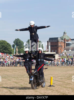 Glasgow, Scozia, 21 luglio, 2013. I membri della Royal segnali Display moto Team, noto come il bianco caschi, effettuando al Glasgow Visualizza 2013 su Glasgow Green. Il team ha iniziato nel 1927; i membri del team sono tutti di servire i soldati in segnali reali che hanno il compito di eseguire sui loro anni settanta 750cc Millennium trionfo TR7V Tiger motocicli in tutto il Regno Unito tra aprile e settembre. Foto Stock