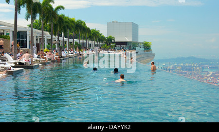 Gli ospiti del Marina Bay Sands godendo di una nuotata presso l'hotel panoramica piscina infinity e tenendo le attrazioni di Singapore lo skyline di Foto Stock