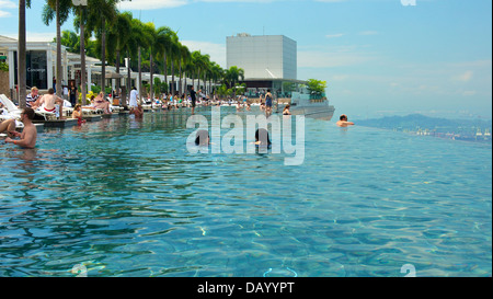 Gli ospiti del Marina Bay Sands godendo un imbibire a posta sul tetto dell'hotel piscina infinity e tenendo le attrazioni di Singapore Foto Stock