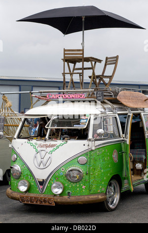 Volkswagen camper van/Bus bus Hippy con tavolo sedie e ombrellone sul tetto Foto Stock