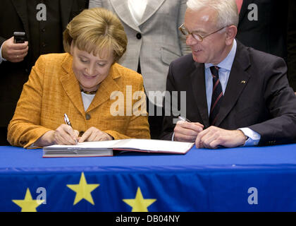 Il cancelliere tedesco Angela Merkel (L) e il Presidente del Parlamento europeo Hans-Gert Poettering (R) firmare il disegno di legge nel corso di una sessione plenaria del Parlamento europeo a Bruxelles, Belgio, 27 giugno 2007. Merkel e Poettering ha firmato la legge sul regolamento per telefono cellulare in roaming in Europa. Foto: Thierry Monasse Foto Stock