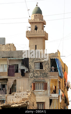 La foto mostra un edificio trasandato davanti ad una moschea il minareto al campo profughi palestinese Shatila a Beirut, Libano, 19 luglio 2007. Foto: Rainer Jensen Foto Stock