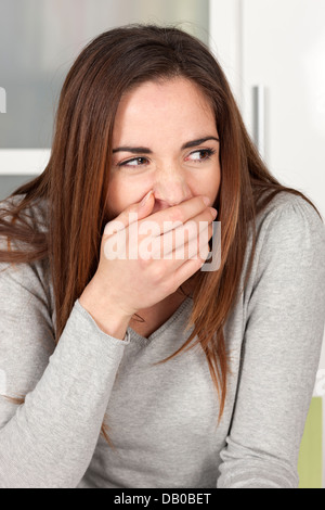 Giovane donna sbadigli a casa Foto Stock