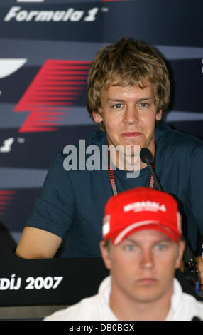 Tedesco di Formula Uno pilota Sebastian Vettel della Toro Rosso si siede dietro il finlandese pilota di Formula Uno Kimi Raikkonen della Ferrari durante una conferenza stampa presso l'Hungaroring race track vicino a Budapest, Ungheria, giovedì, 02 agosto 2007. Il Gran Premio di Ungheria si svolge domenica 05 agosto. Foto: Carmen Jaspersen Foto Stock