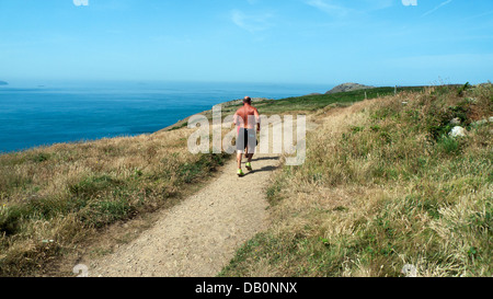 Concorrente in esecuzione su Il Pembrokeshire Coast Path nel 2013 Whitesands Triathalon gara su San Davide testa del Galles REGNO UNITO Foto Stock