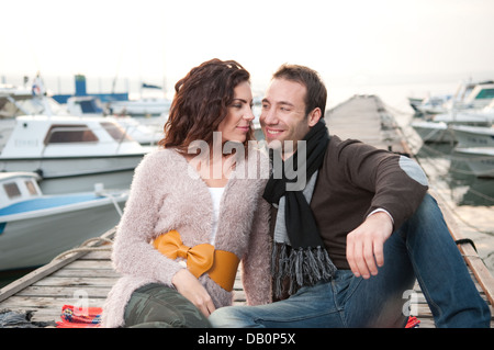 Felice coppia godendo del tempo insieme. Seduto sul molo in legno. Foto Stock