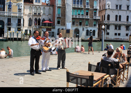 Musicisti di strada a giocare presso i ristoranti di Venezia Foto Stock