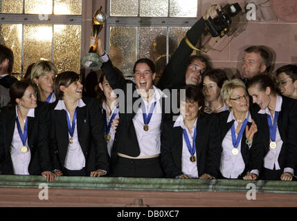 Il capitano del team nazionale tedesco Birgit Prinz (C) pone con la Coppa del Mondo Donne trofeo come essa si erge nel mezzo dei suoi compagni di squadra sul Roemer-balcone a Francoforte sul Meno, Germania, 01 ottobre 2007. La Germania aveva sconfitto il Brasile 2-0 durante la finale si svolge a Shanghai (Cina). Foto: Frank Rumpenhorst Foto Stock