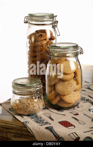 Il cioccolato e i cookie di lavanda e frantumato le nocciole in un vaso sul tavolo rustico con tovaglia e sfondo bianco Foto Stock