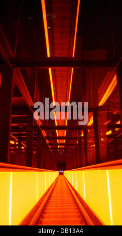 Vista in molto ripida e lunga illuminata di escalator in urlando luce arancione all'ex miniera di carbone Zollverein di Essen, Germania, 25 ottobre 2007. Il cosiddetto "carbone round" aveva deciso nel 1983 di chiudere la miniera di carbone che ha impiegato 5 mila persone e dissotterrato fino a 12.000 tonnellate di carbone al giorno. Oggi il complesso industriale delle Miniere di carbone dello Zollverein è dall'UNESCO Herit Foto Stock