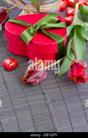 Confezione regalo rossa, tulipani e dolci Foto Stock