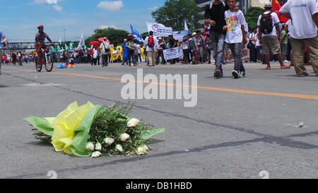 Quezon City, Filippine. 22 Luglio, 2012. Durante l'anti-membro della nazione indirizzo protesta, la polizia ha dato bouquet di fiori ai manifestanti ma gettarla via. Credito: Sherbien Dacalanio/Alamy Live News Foto Stock