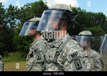 I soldati dell'esercito di Wisconsin Guardia Nazionale XXXII della Polizia Militare Azienda attendere di ricevere un ordine di spostarsi in avanti durante una sommossa esercizio a Fort McCoy, Wis., 16 luglio. La formazione è stata parte del Patriot 2013, una Guardia nazionale nazionale esercizio di risposta t Foto Stock